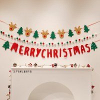 赤、緑、白のポンポンの紐のクリスマス ぬいぐるみボールがクリスマス ツリーを飾り、垂れ下がった壁の背景の周りに装飾を配置します。